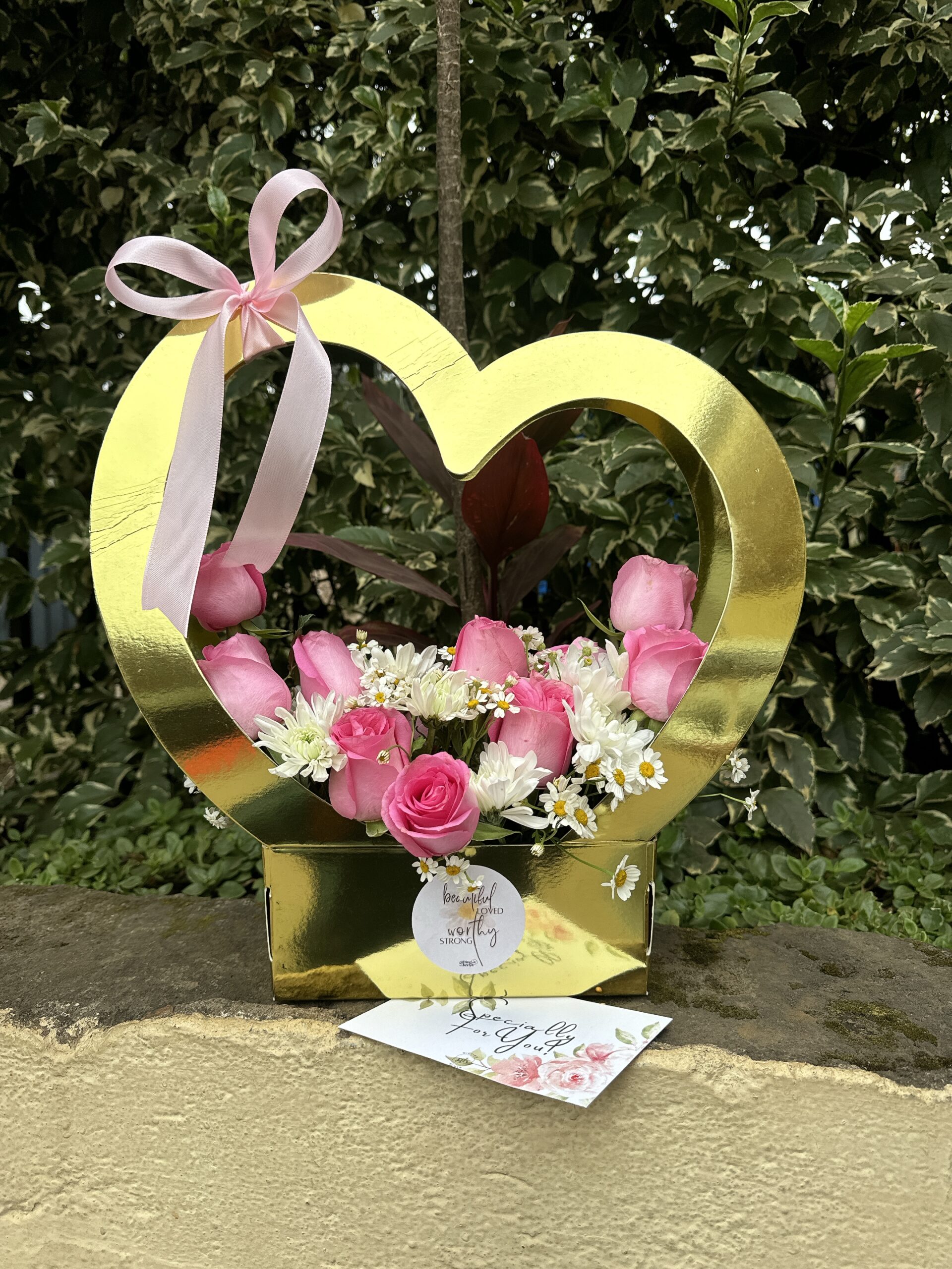 Heart Felt Bloom arrangement with pink roses and white daisies in a gold heart-shaped keepsake box by Gifting Kenya.