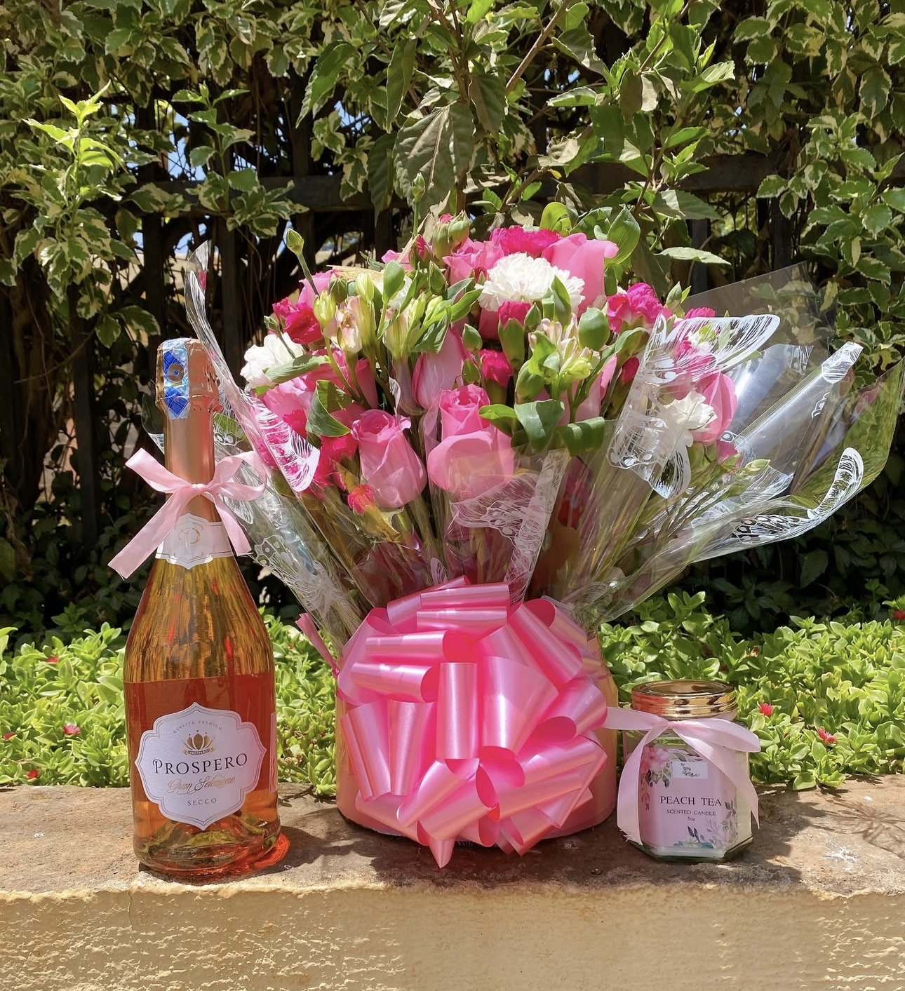 Pink flower bouquet with Prospero Rosé Prosecco and peach tea scented candle by Gifting Kenya.