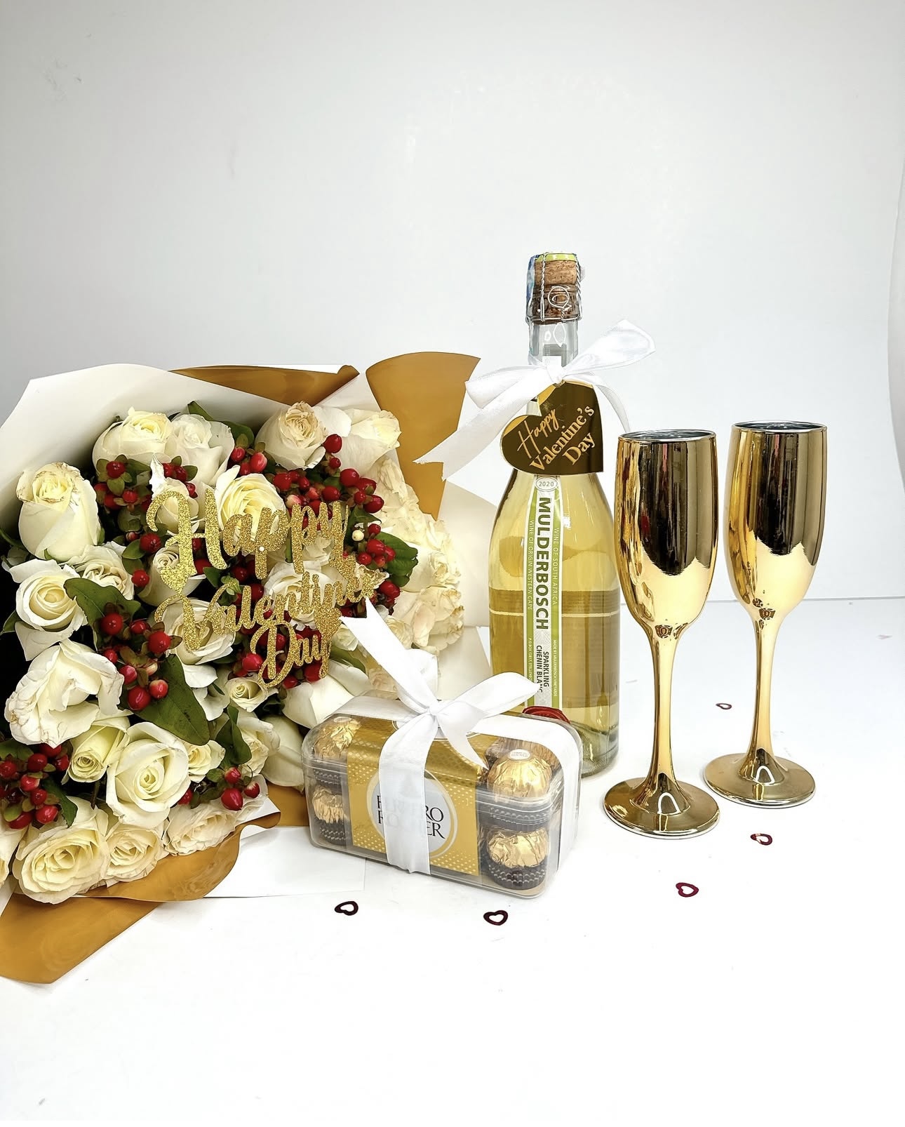 White rose bouquet with sparkling wine, Ferrero Rocher chocolates, and gold champagne flutes by Gifting Kenya.
